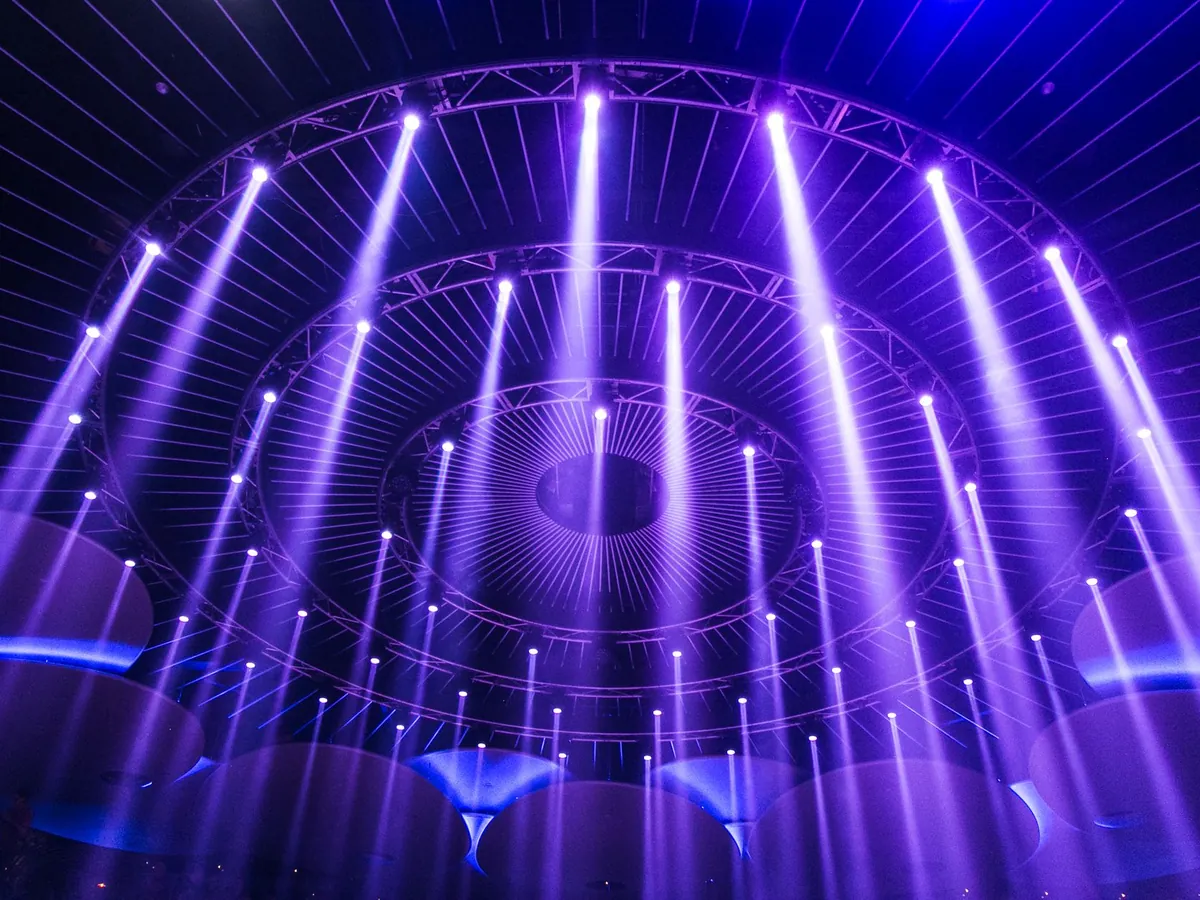 Rows of purple stage lighting beams in a dark venue